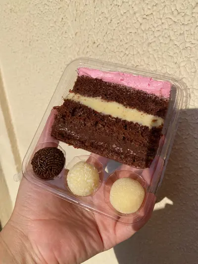 Fatia de bolo de ninho com brigadeiro e docinhos